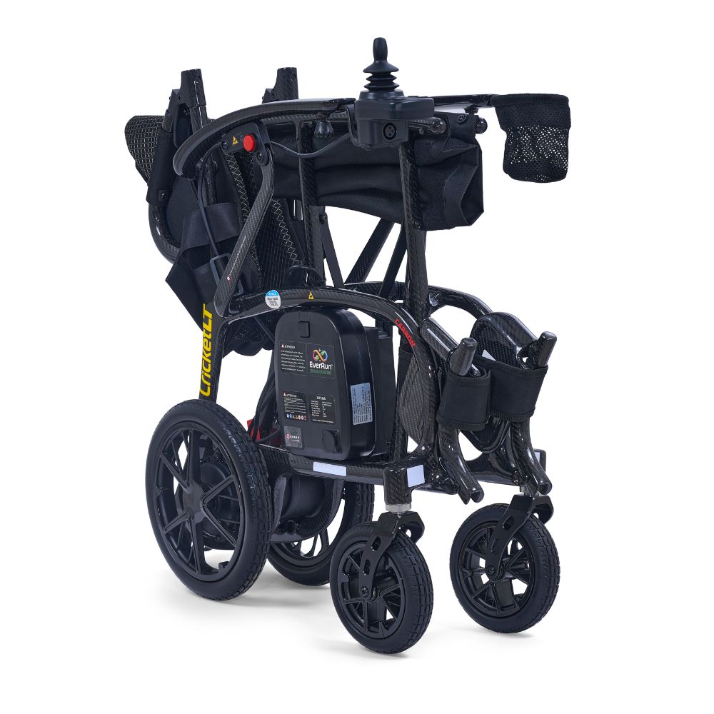 The Golden Cricket LT Side-Folding Carbon Fiber Power Wheelchair features large rear wheels, smaller front wheels, a mesh basket, and a control joystick on the armrest, all in a convenient folded design.